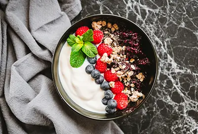 Acai and yogurt bowl with blueberries, strawberries, and granola.